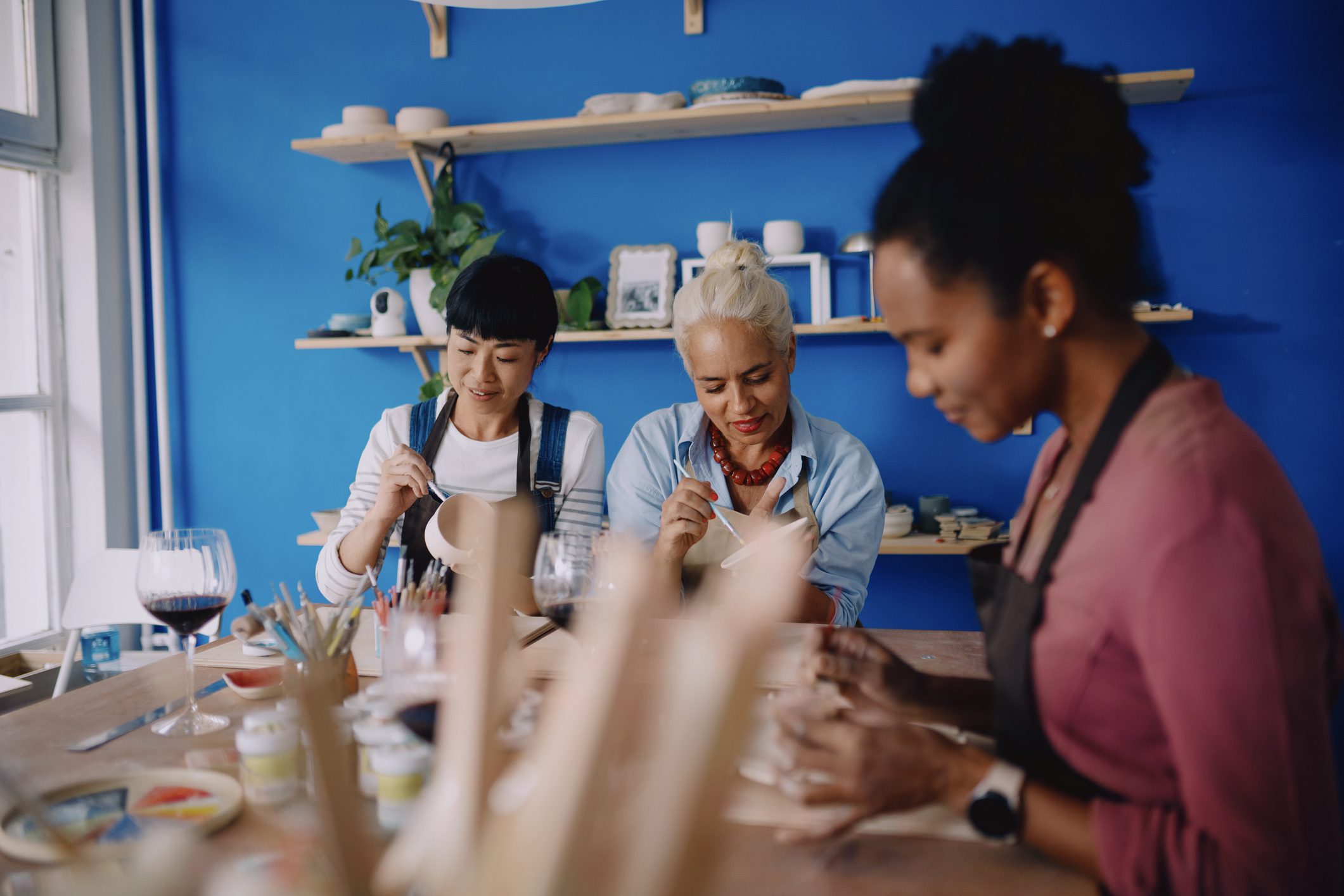 People enjoying pottery class together in a bright studio.